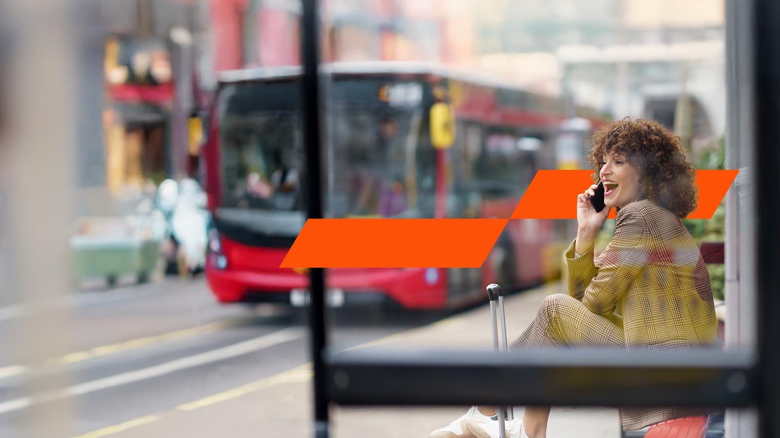 Woman talking on smart phone at bus stop