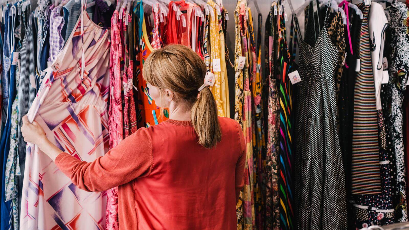 Woman looking at dress hanging at store