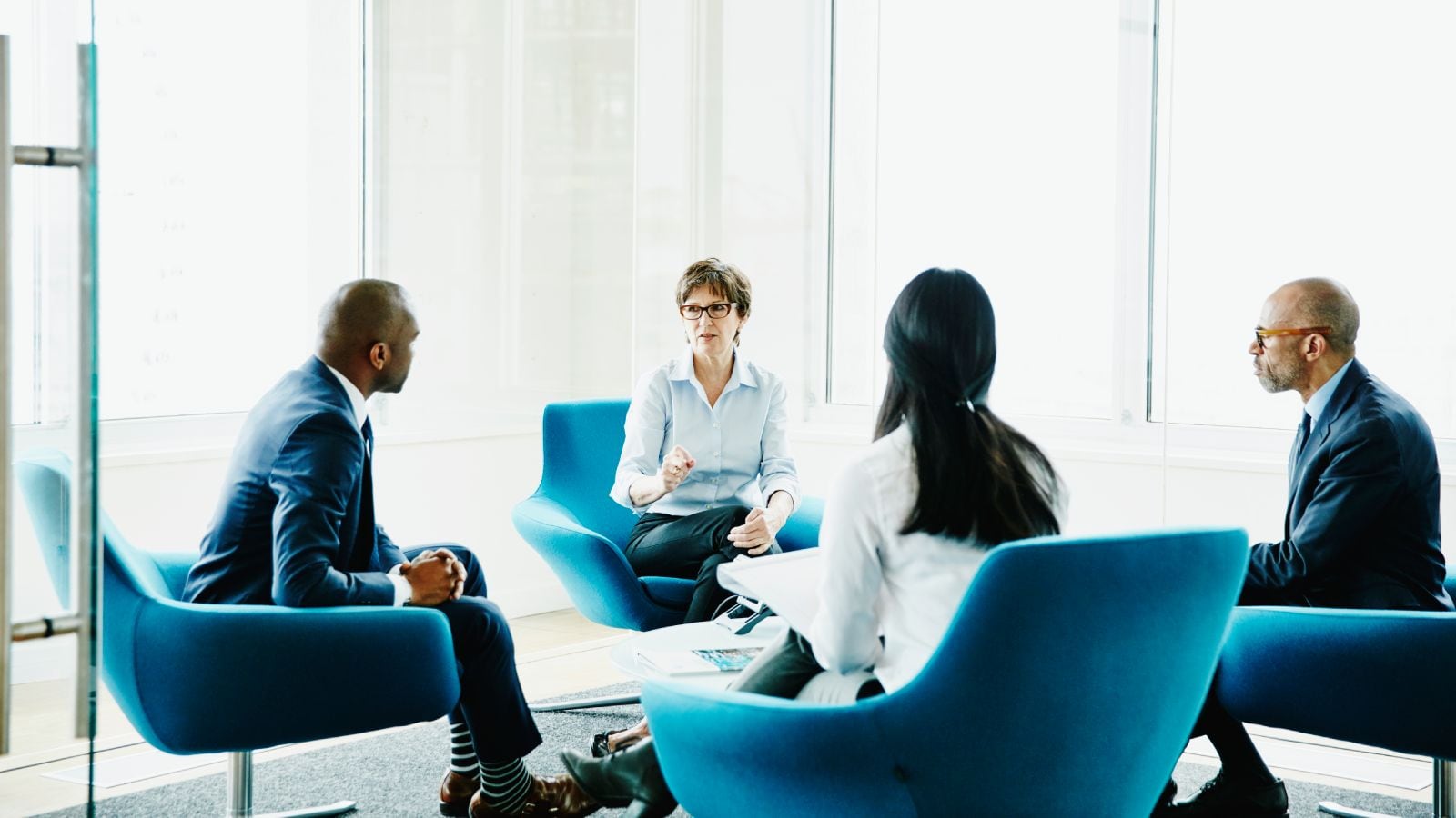 Mature businesswoman leading team meeting in office conference room