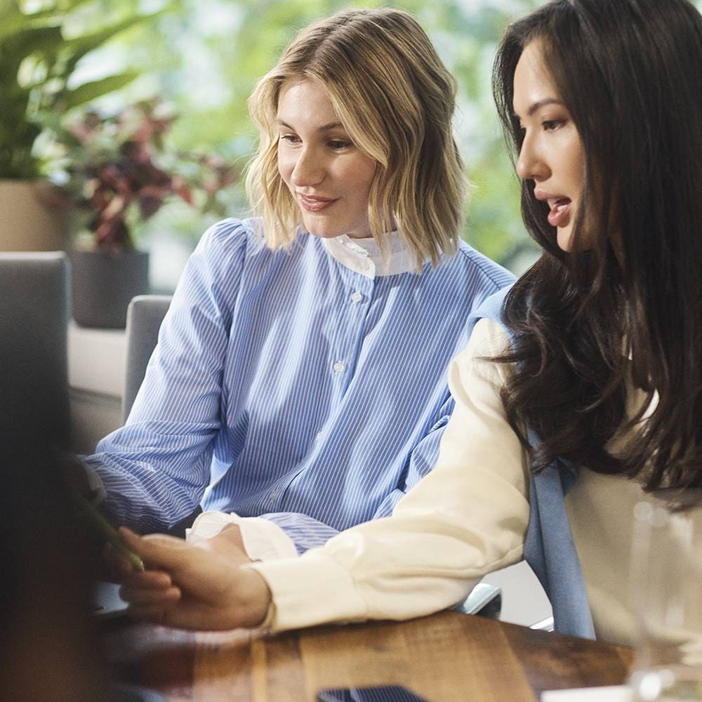 Two women seated at a conference room and discussion a project