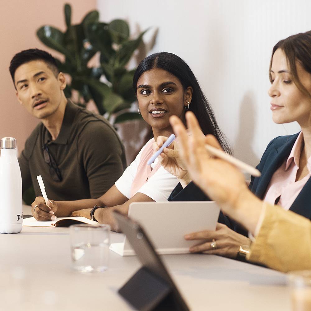 A group of professionals engaged in a team meeting around a table