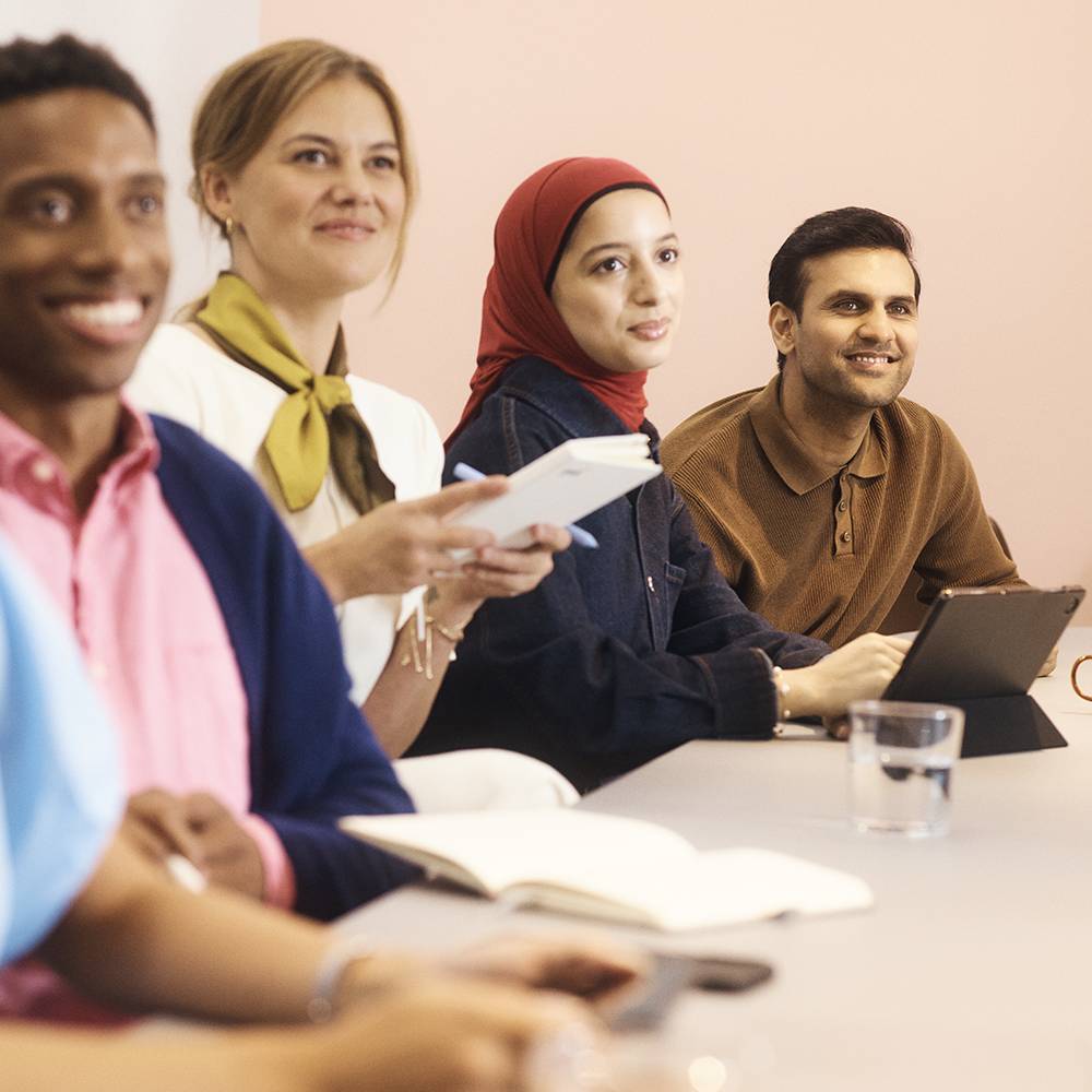A group of individuals seated at a table in a professional meeting environment