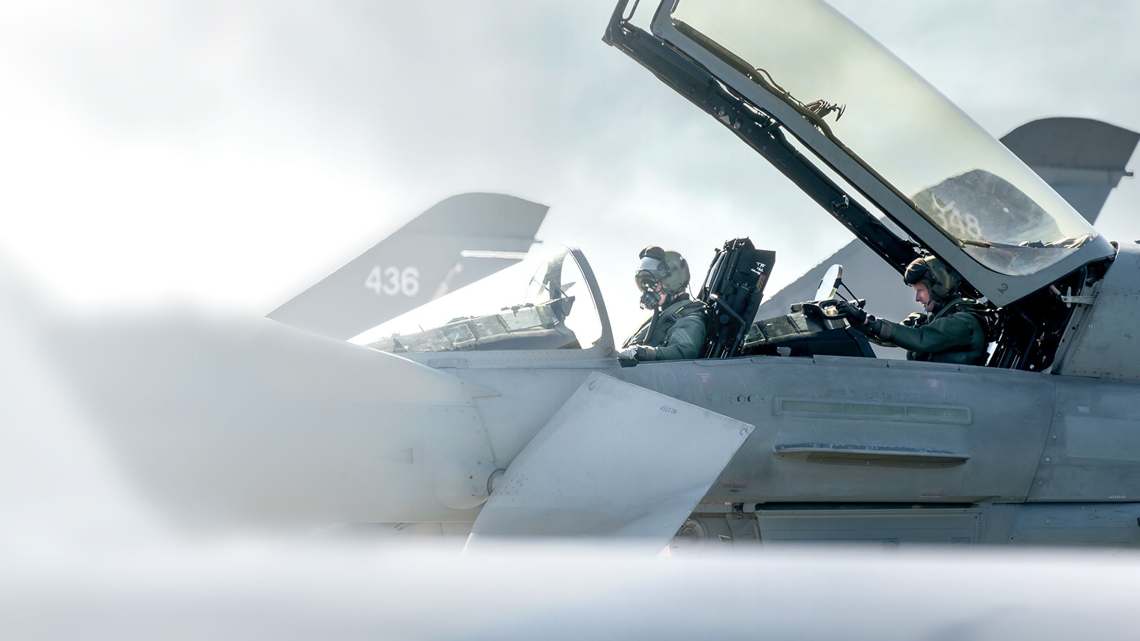 Pilots perform preflight checks in the cockpit